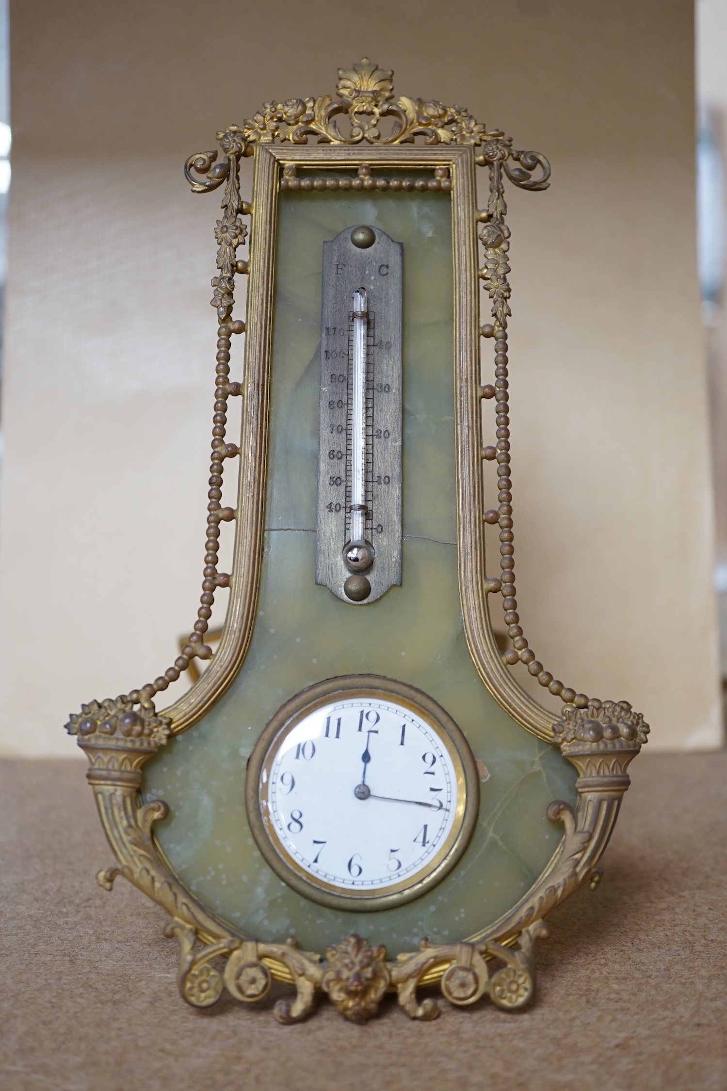 An onyx and gilt metal easel timepiece and thermometer, 20cm high. Condition - fair